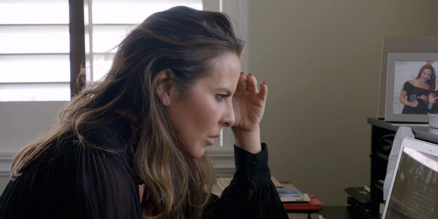 Kate del Castillo sitzt vor einem Computer und stützt den Kopf in ihre Hand Kate del Castillo sitzt vor einem Computer und stützt den Kopf in ihre Hand