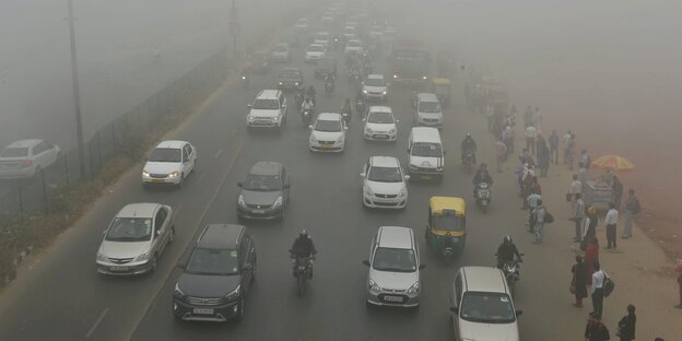 Autos, Mopeds und Rikschas im Smog von Delhi Autos, Mopeds und Rikschas im Smog von Delhi