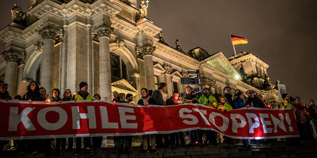 Bei Nacht:viele Menschen vor dem Reichstag, die mit einem Transparent gegen den Kohleabbau protestieren Bei Nacht:viele Menschen vor dem Reichstag, die mit einem Transparent gegen den Kohleabbau protestieren