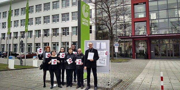 Menschen stehen vorm Goethe-Institut und halten Schilder des GEW hoch Menschen stehen vorm Goethe-Institut und halten Schilder des GEW hoch