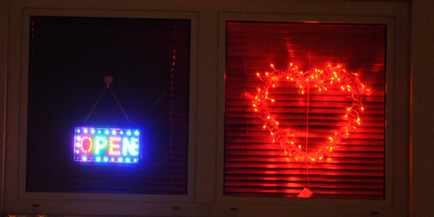 Ein dunkles Fenster mit zwei Leuchtschildern Ein dunkles Fenster mit zwei Leuchtschildern