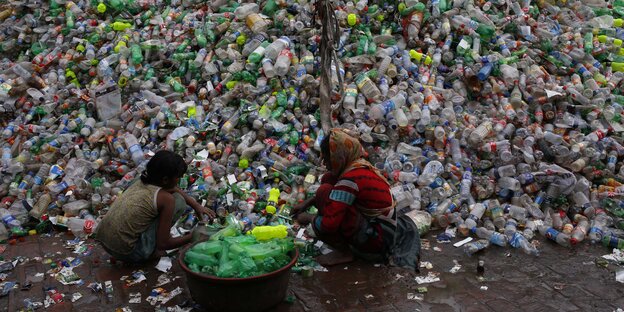 Zwei Mädchen sortieren Plastikflaschen Zwei Mädchen sortieren Plastikflaschen