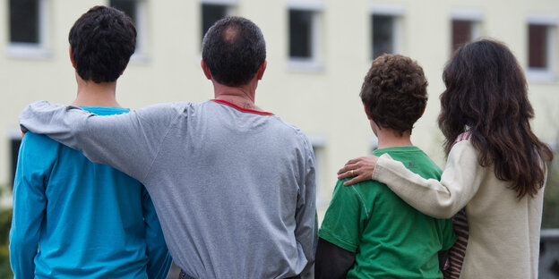 Eine Familie mit zwei Söhnen sitz eng beinander Eine Familie mit zwei Söhnen sitz eng beinander