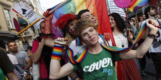 Menschen tragen regenbogenfarbene Tücher und feiern Menschen tragen regenbogenfarbene Tücher und feiern