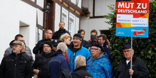 Menschen stehen vor einem Fachwerkhaus Menschen stehen vor einem Fachwerkhaus