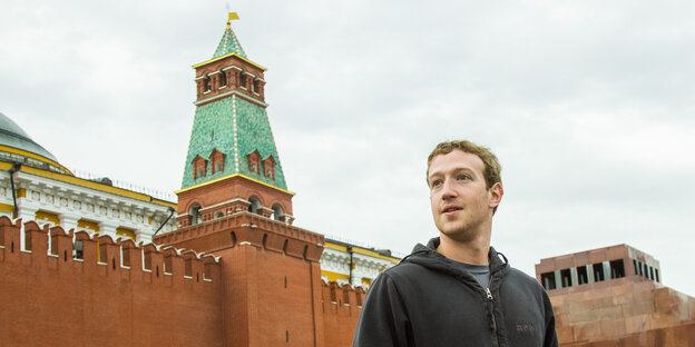 ein Mann vor einer roten Mauer, dahinter ein roter Turm - es ist Marc Zuckerberg in Moskau ein Mann vor einer roten Mauer, dahinter ein roter Turm - es ist Marc Zuckerberg in Moskau
