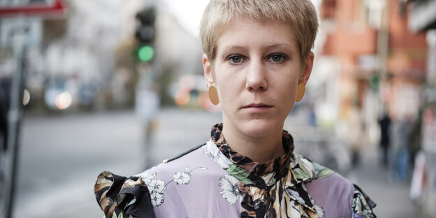Die Schriftstellerin Jovana Reisinger in einem bunten Kleid auf dem Gehweg der Sonnenallee. Die Schriftstellerin Jovana Reisinger in einem bunten Kleid auf dem Gehweg der Sonnenallee.
