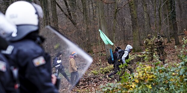 Behelmte Polizisten und vermummte Demonstranten Behelmte Polizisten und vermummte Demonstranten