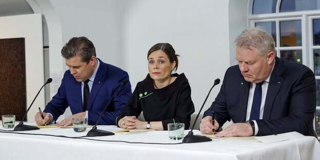 Eine Frau und zwei Männer an einem Tisch Eine Frau und zwei Männer an einem Tisch