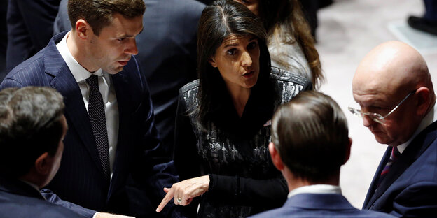 US-Botschafterin Nikki Haley redet mit mehreren Männern US-Botschafterin Nikki Haley redet mit mehreren Männern