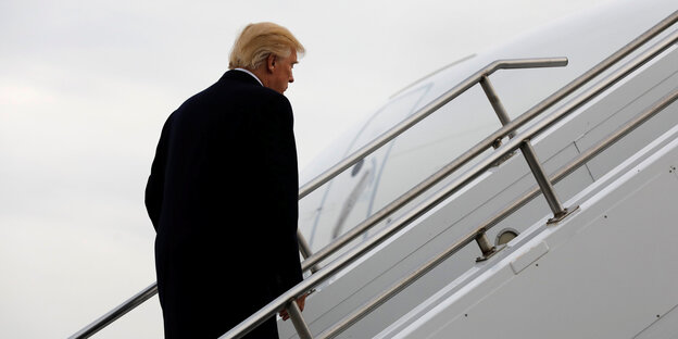 Trump steigt die Treppe zu einem Flugzeug hoch Trump steigt die Treppe zu einem Flugzeug hoch