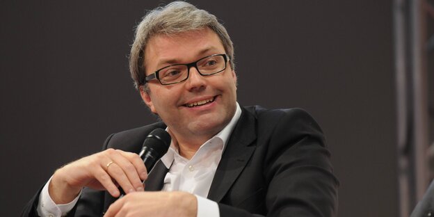 ein Mann mit Mikrofon in der Hand lacht ein Mann mit Mikrofon in der Hand lacht