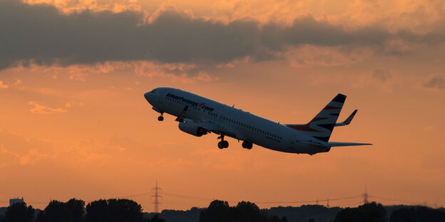 Ein Flugzeug vor rosafarbenem Himmel