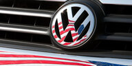 Auf einer Kühlerhaube prangt ein VW-Symbol, in dem sich die USA-Fahne spiegelt