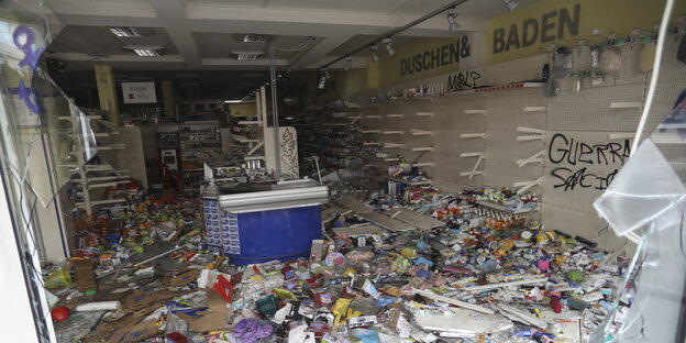 Blick durch ein zerstörtes Schaufenster eines verwüsteten und geplünderten Drogeriemarkts im Schanzenviertel Blick durch ein zerstörtes Schaufenster eines verwüsteten und geplünderten Drogeriemarkts im Schanzenviertel