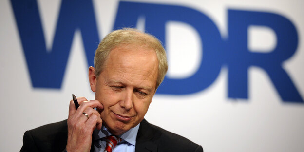 Tom Buhrow kratzt sich an der Backe und erhält bei einen Stift in der Hand Tom Buhrow kratzt sich an der Backe und erhält bei einen Stift in der Hand