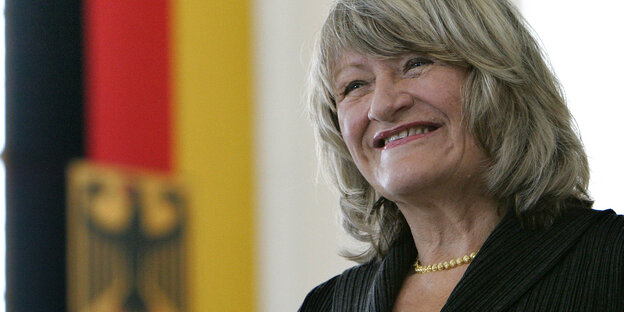 eine grinsende Frau neben einer Deutschlandfahne eine grinsende Frau neben einer Deutschlandfahne
