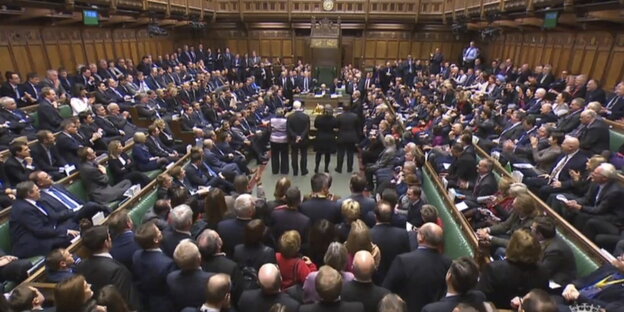 Mitglieder des House of Commons stehen nach einer Abstimmung über das Veto-Recht des britischen Parlaments über ein Brexit-Abkommen zusammen Mitglieder des House of Commons stehen nach einer Abstimmung über das Veto-Recht des britischen Parlaments über ein Brexit-Abkommen zusammen