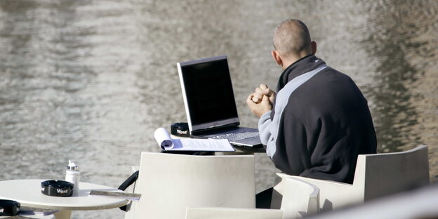 ein Mann sitzt mit Laptop im Café ein Mann sitzt mit Laptop im Café