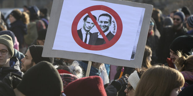 Ein Demonstrierender hält beim Protest gegen die neue österreichische Regierung ein Schild hoch, auf dem Bundeskanzler Kurz und Vizekanzler Strache durchgestrichen sind. Ein Demonstrierender hält beim Protest gegen die neue österreichische Regierung ein Schild hoch, auf dem Bundeskanzler Kurz und Vizekanzler Strache durchgestrichen sind.