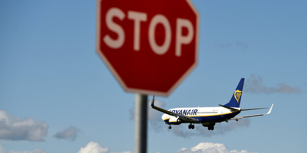 Ein Flugzeug fliegt hinter einem Stoppschild Ein Flugzeug fliegt hinter einem Stoppschild