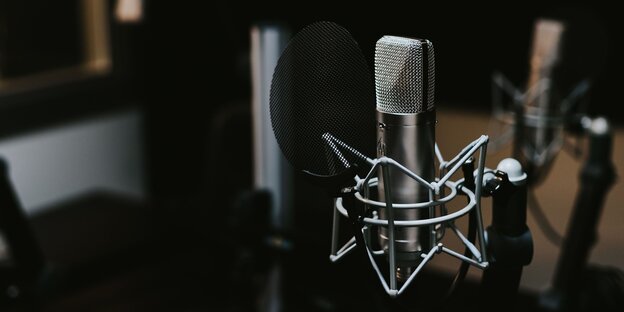 Ein Mikrofon steht in einem Tonstudio Ein Mikrofon steht in einem Tonstudio