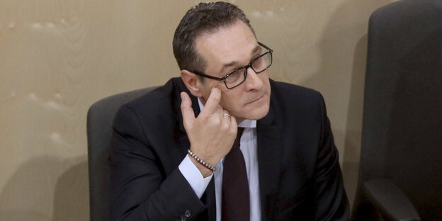 Ein Mann mit Brille fasst sich an das Auge Ein Mann mit Brille fasst sich an das Auge