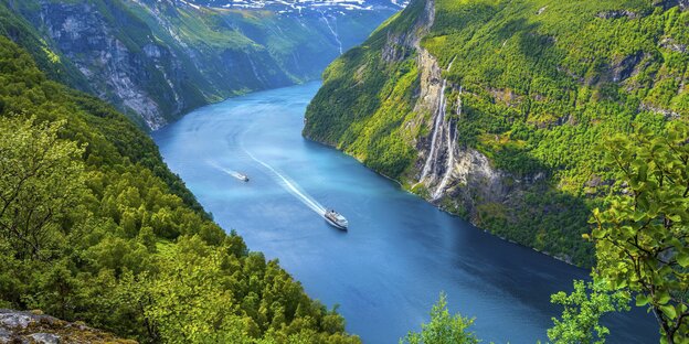 Ein Kreuzfahrtschiff fährt durch eine paradiesische Schlucht Ein Kreuzfahrtschiff fährt durch eine paradiesische Schlucht