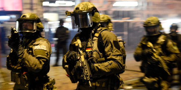 Spezialkräfte der Polizei stehen am mit Waffen in der Hand auf der Straße