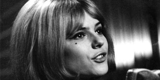 Eine Frau mit blondem Bob singt in ein Mikrofon Eine Frau mit blondem Bob singt in ein Mikrofon