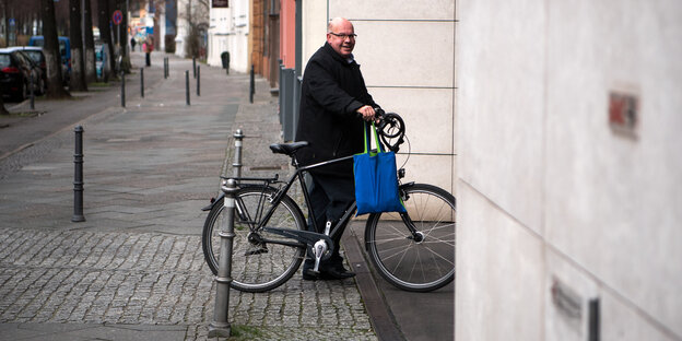 Ein Mann steht neben seinem Fahrrad Ein Mann steht neben seinem Fahrrad