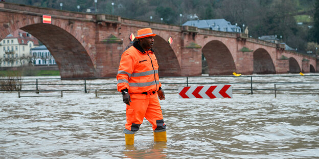 Ein Mann steht im Hochwasser des Neckars bei Heidelberg Ein Mann steht im Hochwasser des Neckars bei Heidelberg