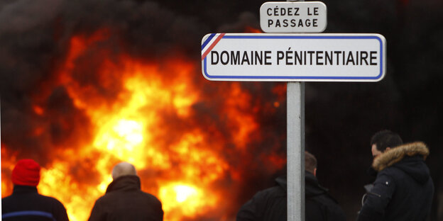 Flammen und Rauch hinter einem Verkehrsschild Flammen und Rauch hinter einem Verkehrsschild
