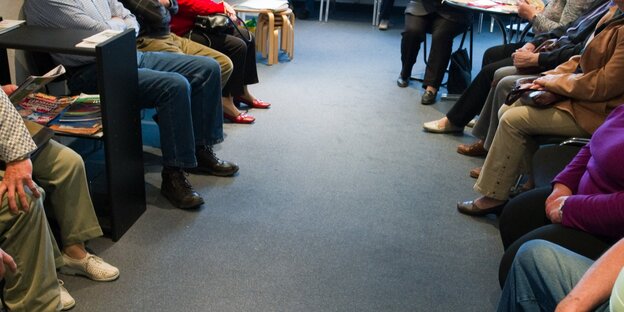 Menschen sitzen in einem Wartezimmer Menschen sitzen in einem Wartezimmer