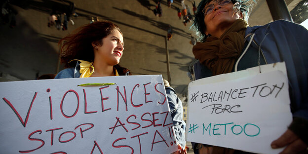 Zwei Frauen halten Schilder mit den Worten "Gewalt. Stop. Genug!" und dem Hashtag #BalanceTonPorc, der französischen Variante von #MeToo Zwei Frauen halten Schilder mit den Worten "Gewalt. Stop. Genug!" und dem Hashtag #BalanceTonPorc, der französischen Variante von #MeToo