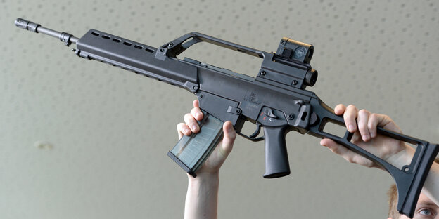 Jemand hält ein Sturmgewehr hoch Jemand hält ein Sturmgewehr hoch