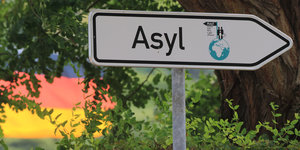 Ein Schild in Form eines Pfeils. Darauf geschrieben ist das Wort "Asyl".