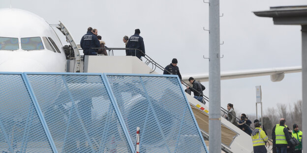 Menschen auf einer Gangway, die gerade in ein Flugzeug steigen