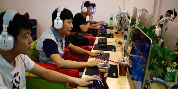 Chinesische Jugendliche mit Kopfhörern vor Bildschirmen in einem Internet-Cafe' Chinesische Jugendliche mit Kopfhörern vor Bildschirmen in einem Internet-Cafe'