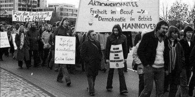 Eine Menschenmenge mit Plakaten geht auf einer Straße in Oldenburg. Die Plakate wenden sich gegen Berufsverbote. Eine Menschenmenge mit Plakaten geht auf einer Straße in Oldenburg. Die Plakate wenden sich gegen Berufsverbote.