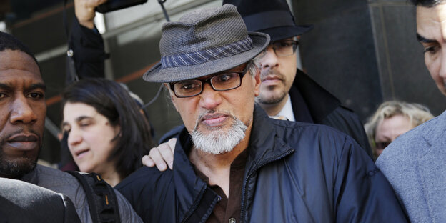 Ravi Ragbir läuft, links und rechts von zwei Männern begleitet Ravi Ragbir läuft, links und rechts von zwei Männern begleitet