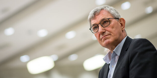 Linken-Parteichef Bernd Riexinger guckt nach oben. Hinter ihm hängen viele Lampen Linken-Parteichef Bernd Riexinger guckt nach oben. Hinter ihm hängen viele Lampen