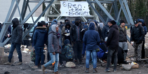 Geflüchtete im Flüchtlingscamp in Calais (Frankreich) in einer Gruppe unter dem Banner «Öffnet die Grenzen» Geflüchtete im Flüchtlingscamp in Calais (Frankreich) in einer Gruppe unter dem Banner «Öffnet die Grenzen»