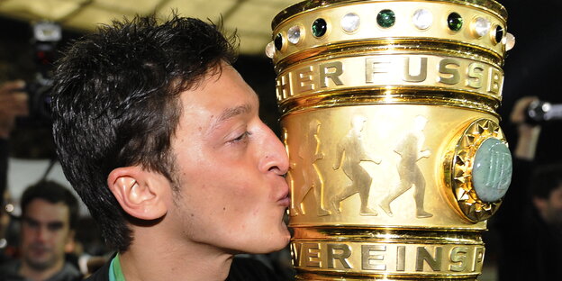 ein Mann küsst einen großen goldenen Pokal ein Mann küsst einen großen goldenen Pokal