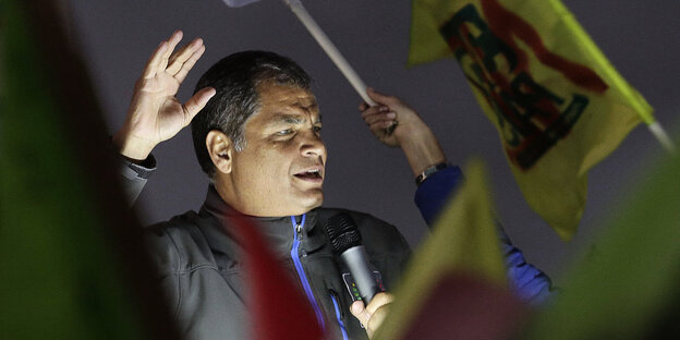 Rafael Correa hält eine Rede, viele Menschen um ihn schwenken Fahnen Rafael Correa hält eine Rede, viele Menschen um ihn schwenken Fahnen