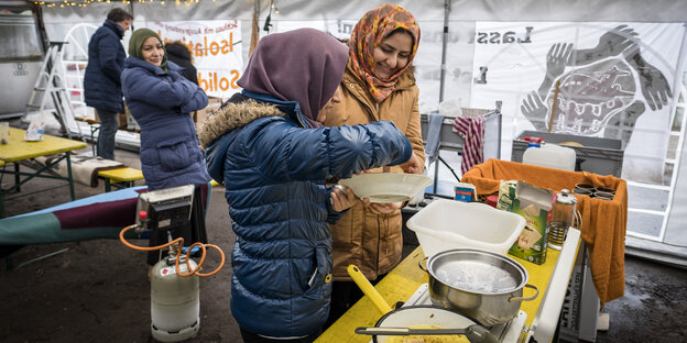 Frauen kochen in einem Zelt Frauen kochen in einem Zelt