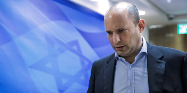 Naftali Bennett vor der Abbildung eines Davidsterns an einer Wand