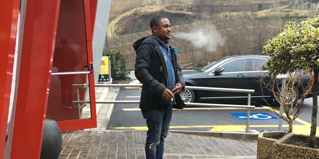 Mann steht am Autobahnrastplatz und raucht Mann steht am Autobahnrastplatz und raucht