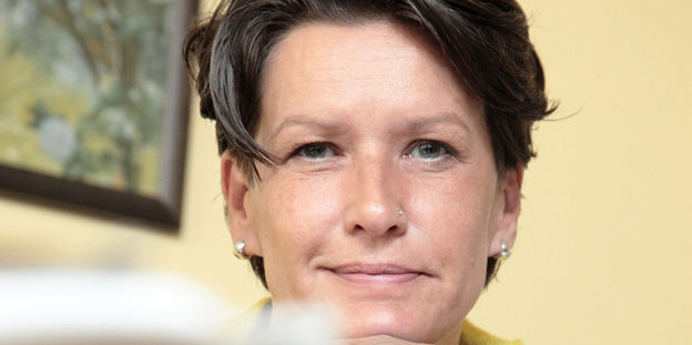 Eine 49-jährige Frau mit braunen Haaren schaut direkt in die Kamera und lächelt. Eine 49-jährige Frau mit braunen Haaren schaut direkt in die Kamera und lächelt.