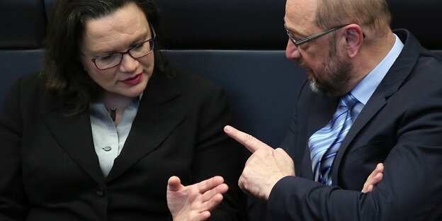 Eine Frau und ein Mann unterhalten sich und gestikulieren dabei Eine Frau und ein Mann unterhalten sich und gestikulieren dabei